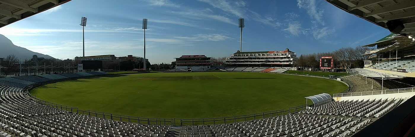 Empty Newlands cricket ground, with seating around the outfield and mountains to the left